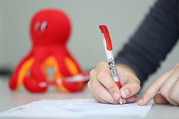 Hand mit Kugelschreiber der Schreibwerkstatt. Foto: Universität Osnabrück/Reimar Ott