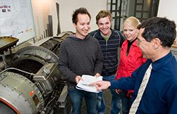 Studierende und Lehrender vor einer Maschine. Foto: Hochschule Osnabrück